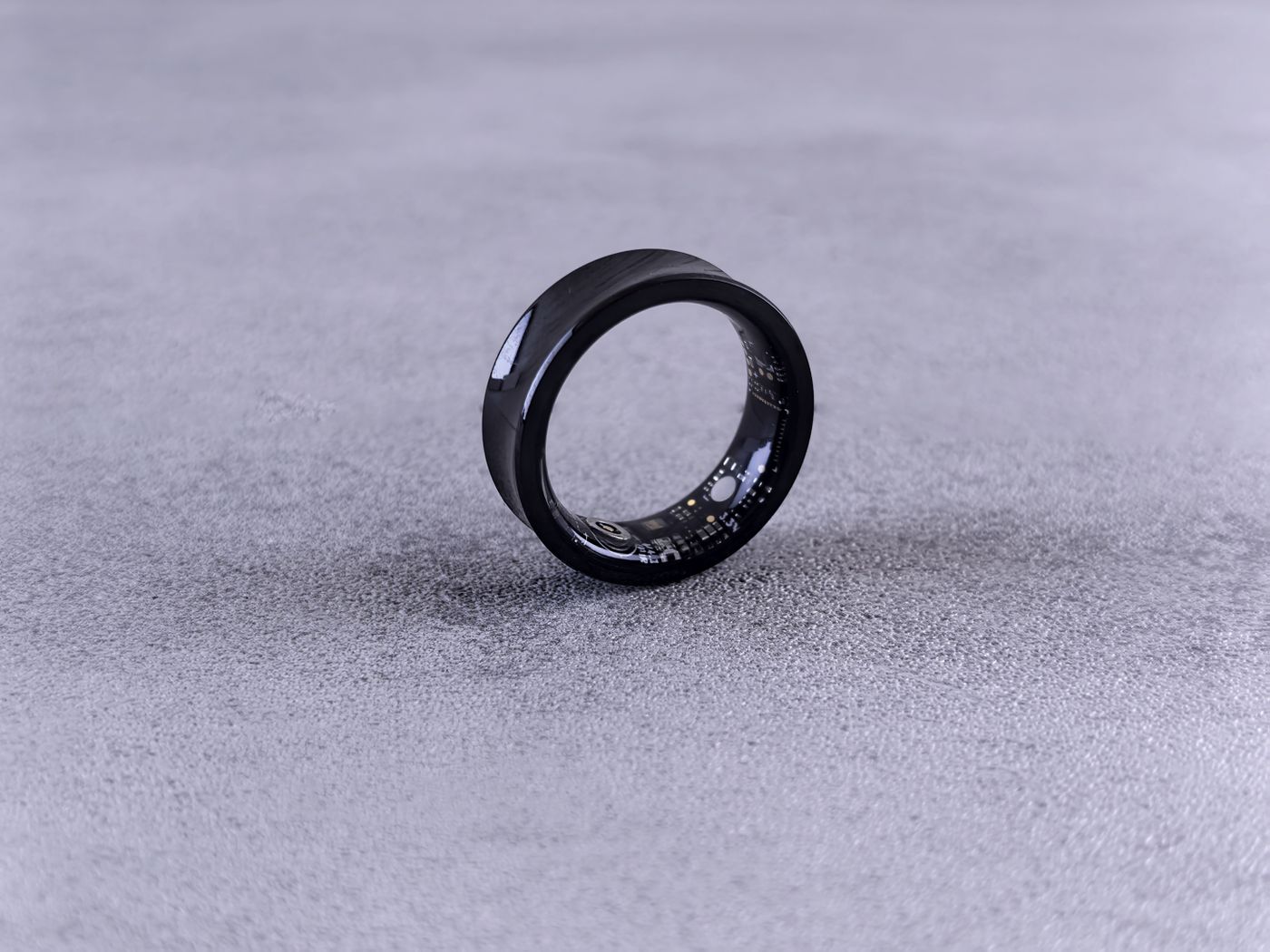 Schwarzer Smart Ring auf grauem Untergrund